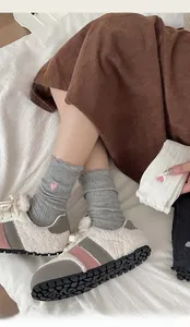 Gros plan détaillé de chaussettes en coton côtelé avec broderie cœur rose et bord ondulé