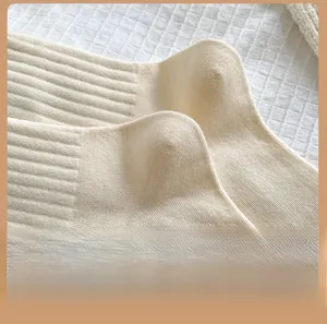 Detail view of cream ribbed knit cotton socks featuring a reinforced ergonomic heel design