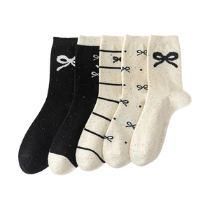 Five pairs of cotton bow socks in black and cream with colorful speckled knit patterns