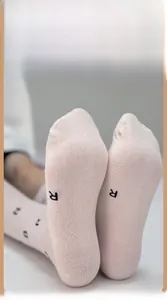 Macro detail of soft light pink cotton calf socks with black letter print and smooth texture