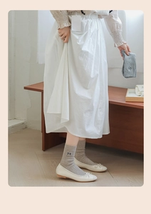 Detailed view of light grey ribbed cotton socks with delicate bow embroidery detail