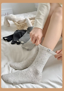 Detail of speckled knit crew socks in four colors with dog love fabric label patches