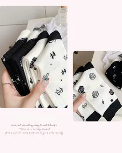 Close-up of white cotton socks with elegant bow and camellia flower knit patterns