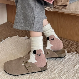 Women's khaki suede clogs paired with white cotton crew socks featuring pink bear patterns