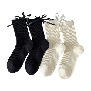 White and black mid-calf cotton socks featuring vertical ribbing and ribbon bow detail