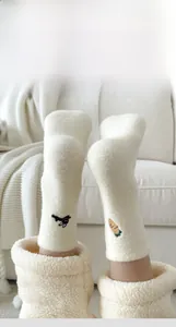 Close-up of thick cream thermal socks with cute embroidery and flat seam detail