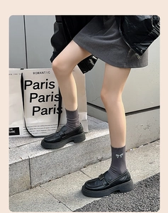 Detail of dark grey ribbed socks with a sparkly bow paired with black platform loafers
