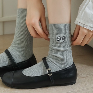 Gray ribbed crew socks featuring delicate black bow embroidery with Mary Jane shoes