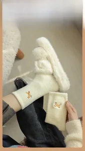 Close-up of plush thermal fox embroidery socks and fuzzy slippers in soft cream white