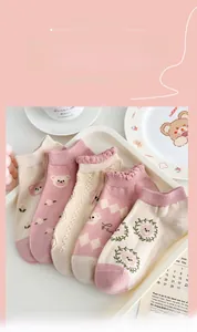 Flat lay of five pairs of cotton socks featuring cartoon bears and lace floral patterns