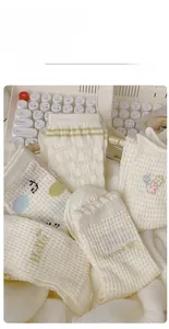 Close-up of mesh cotton crew socks with smiley face and floral patterns on keyboard
