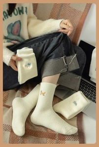 Detailed view of plush cream thermal socks with cute animal embroidery and ribbed cuffs