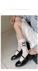 Close-up of white ribbed crew socks with black satin bows paired with Mary Jane shoes