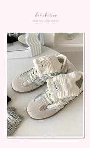 Detail of silver balletcore sneakers featuring cream ruffled lace and brand tongue label