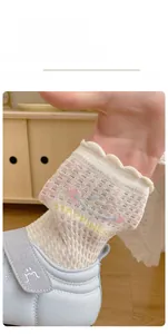 Detail of breathable summer mesh socks with smiley face and HAPPINESS text for kids