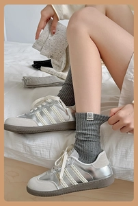 Close-up of dark grey ribbed cotton socks featuring a white dog motif woven label