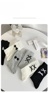 Detail of JK style cotton socks with black bows and pearls in black, white, and grey