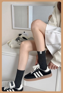 Close-up of dark grey cotton crew socks worn with retro black and white sneakers