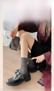 Detailed view of grey socks with red heart jacquard and burgundy embroidered bow accents