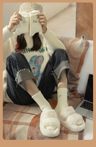 Detail of cream plush socks with cute animal embroidery and thick fuzzy winter texture