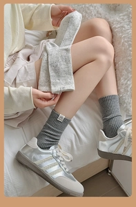 Detail of ribbed knit crew socks with cute fabric tags shown with sneakers