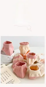 Close-up of ruffled cuff baby socks with floral patterns in soft pastel pink tones