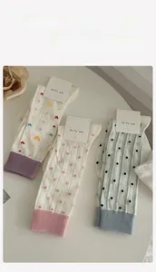 Detailed view of three cotton socks with heart, bow, and polka dot knit patterns