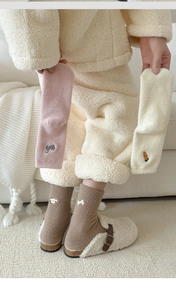 Detail of plush winter socks with cute animal embroidery in pink, beige and brown
