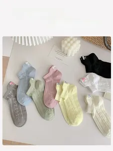Detail of colorful knitted socks with delicate side bow embroidery and ribbed texture