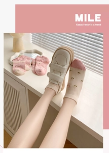 Detail of pink cotton socks with flower patterns paired with white velcro sneakers