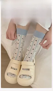 Detail of breathable heart polka dot crew socks with blue ribbed cuffs and stripes