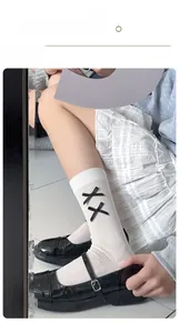 White crew socks with black ribbons paired with Mary Jane shoes and a plaid skirt