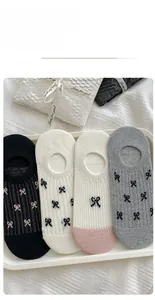 Detailed view of four pairs of ribbed invisible socks with bow patterns in a tray