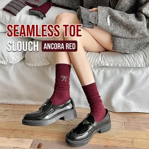 Dark red ribbed knit slouch socks with white bow embroidery styled with black loafers