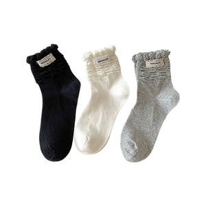 Three pairs of ruffled crew socks in black, white and grey with ballet style lace labels