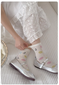 Close-up of girls sheer mesh socks with colorful polka dots and silver Mary Jane shoes