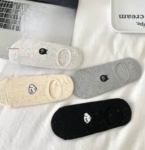 Close-up of low cut cotton socks with colorful flecks and small animal embroidery details