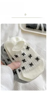 Close-up of women's cotton boat socks featuring small black bow embroidery detail