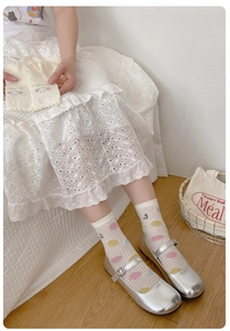 Detail of white mesh crew socks with colorful polka dots and happiness embroidery