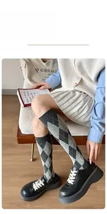 Close-up of diamond pattern knee-high socks in grey and black knit cotton fabric