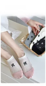 Detailed close-up of ribbed cotton no-show socks with cute black bow pattern and pink toe