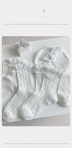 Close-up of white mesh socks with lace bow detail and breathable honeycomb texture