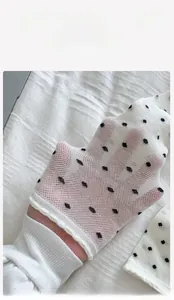 Detailed view of breathable white mesh socks with black polka dots and wavy edge design