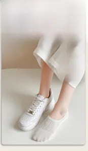 Close-up of beige thin no-show socks with breathable mesh texture on feet