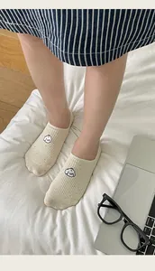 Detail of beige low-cut sock featuring a cute cartoon dog embroidery and ribbed texture