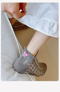 Close-up of grey knit ankle socks featuring pink bow embroidery and white heart pattern