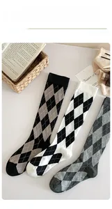 Detail view of argyle knee-high socks in assorted colors with ribbed cuffs for women