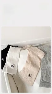 Detail of cotton crew socks with fine vertical stripes and elegant bow embroidery