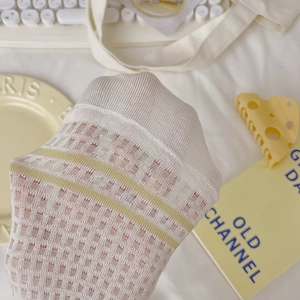 Breathable white mesh socks with yellow stripes in a cozy aesthetic lifestyle setting