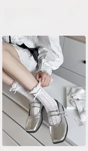 Detail of white cotton mid-calf socks with sweet ribbon bow and ruffled elastic cuffs